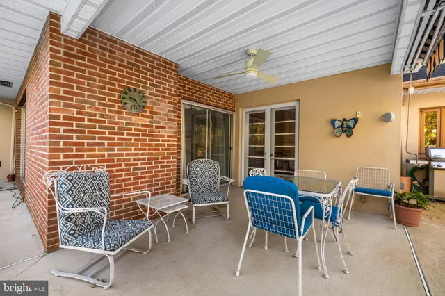 a view of a patio with table and chairs with wooden floor and fence