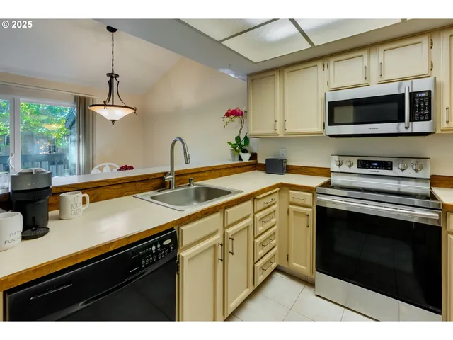 a kitchen with stainless steel appliances granite countertop a sink a stove and microwave
