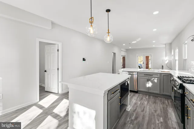 a kitchen with a sink a counter top space stainless steel appliances and a window