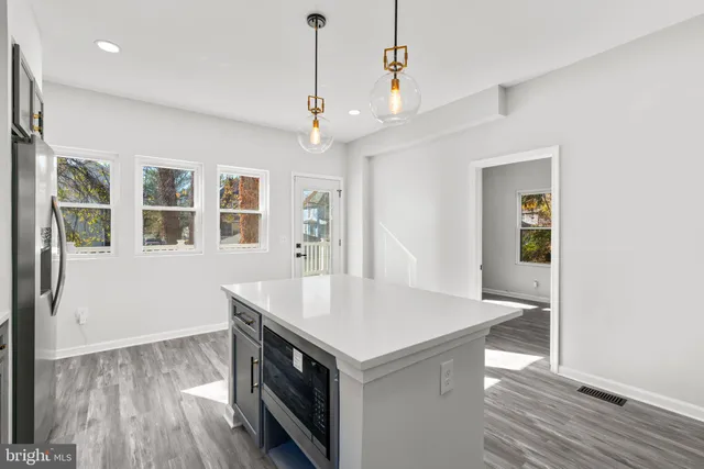 a kitchen with a stove and a wooden floor