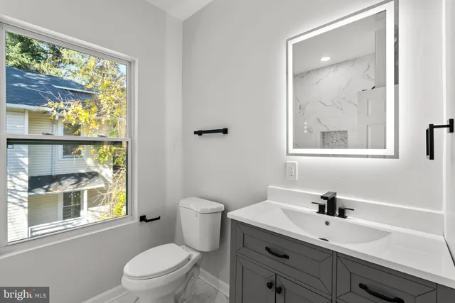 a bathroom with a sink a toilet and a window