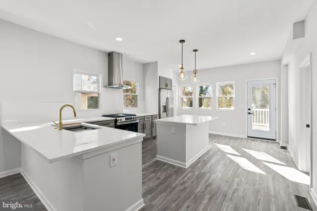 a kitchen with a sink a stove a refrigerator and white cabinets