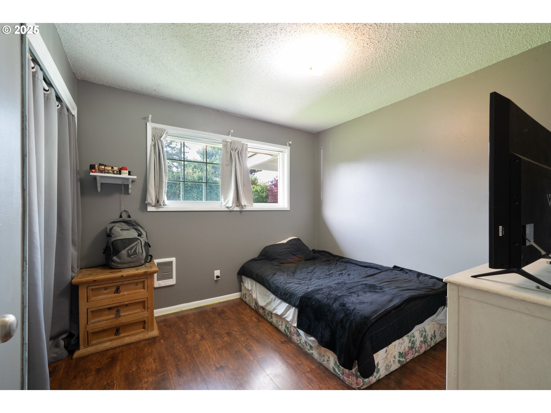 3195 Fitzpatrick Road Tillamook, OR 97141 - Photo 20 of 31 a bedroom with a bed and flat tv screen on the dresser