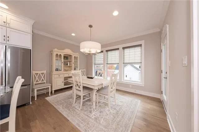 a dining room with furniture a chandelier and wooden floor