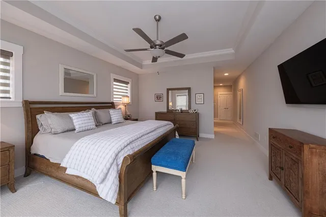 a spacious bedroom with a bed and a flat screen tv