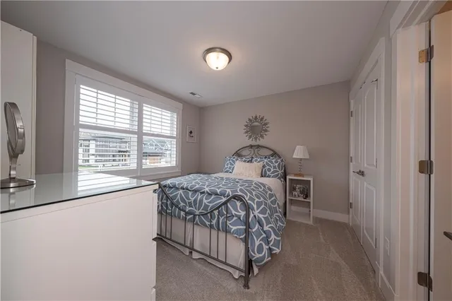 a bedroom with a bed and a dresser next to a window