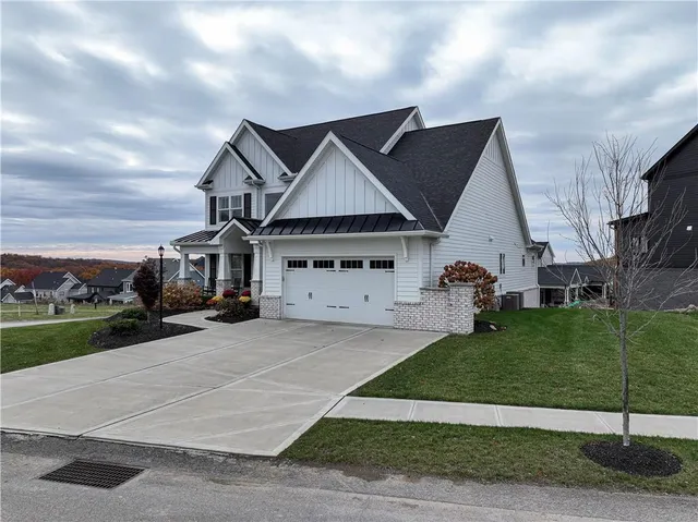 a front view of a house with a garden and yard