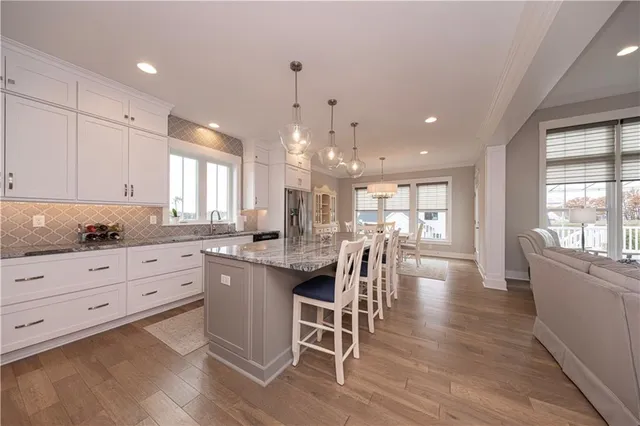 a kitchen with white cabinets counter and chairs