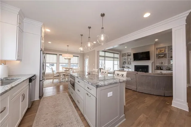 a large kitchen with kitchen island a large counter space a sink stainless steel appliances and cabinets