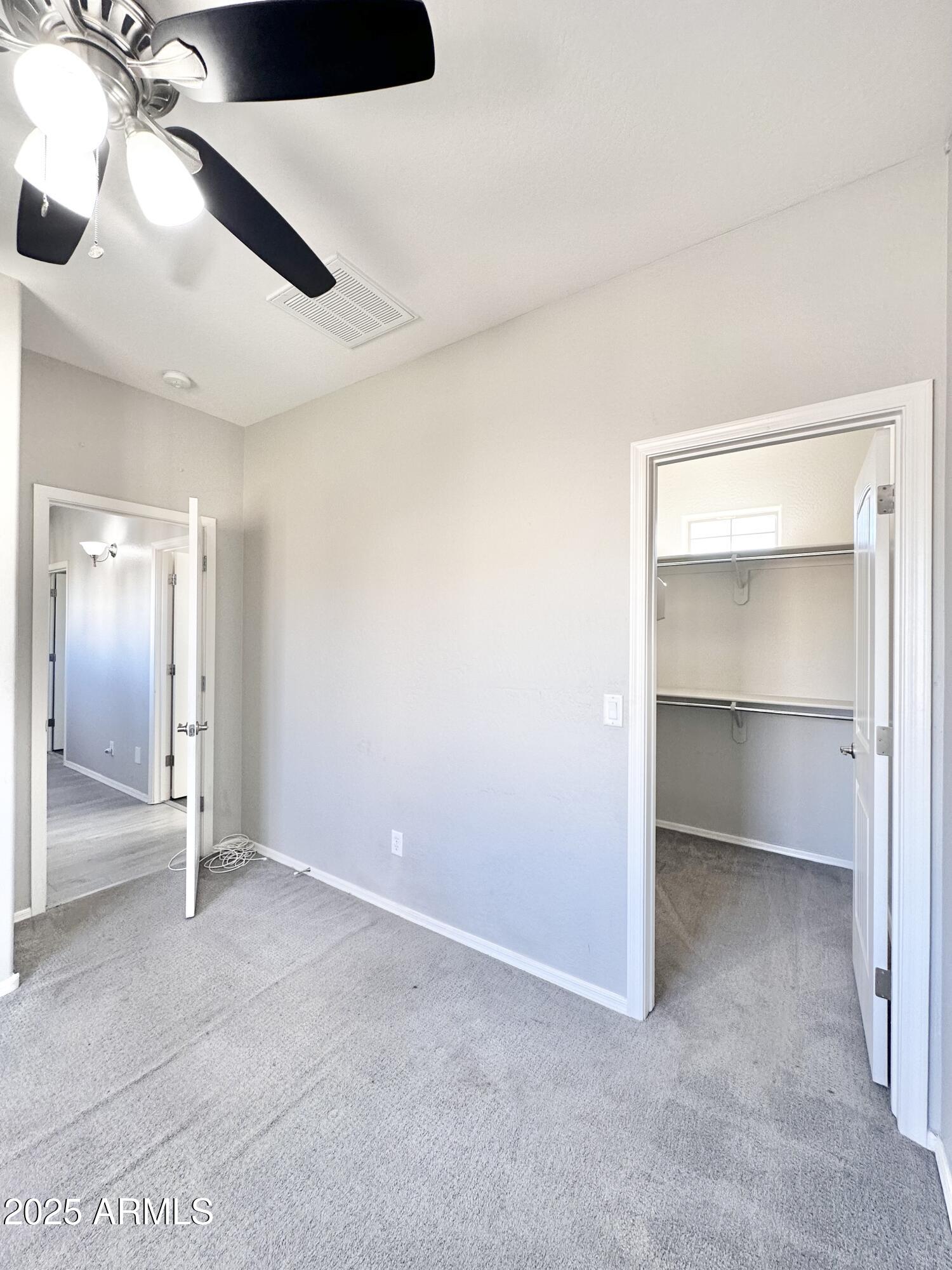 16511 West Tether Trail Surprise, AZ 85387 - Photo 60 of 88 an empty room with a ceiling fan and a bathroom
