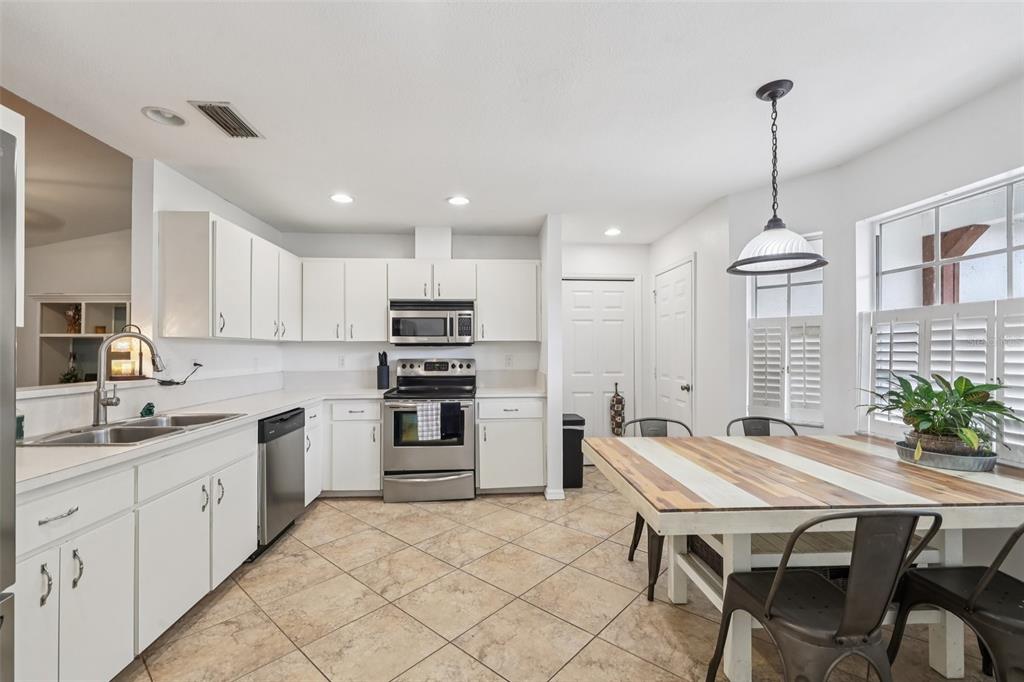 12315 Fort King Road Dade City, FL 33525 - Photo 27 of 77 a kitchen with refrigerator a sink and chairs