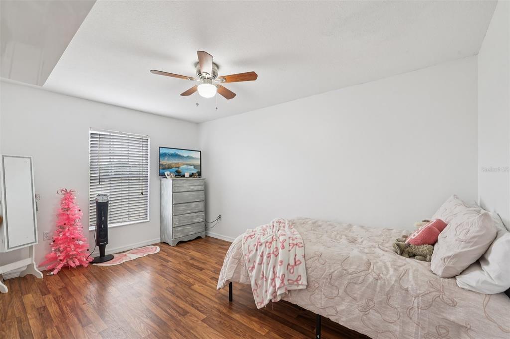 12315 Fort King Road Dade City, FL 33525 - Photo 30 of 77 a bedroom with a bed and wooden floor