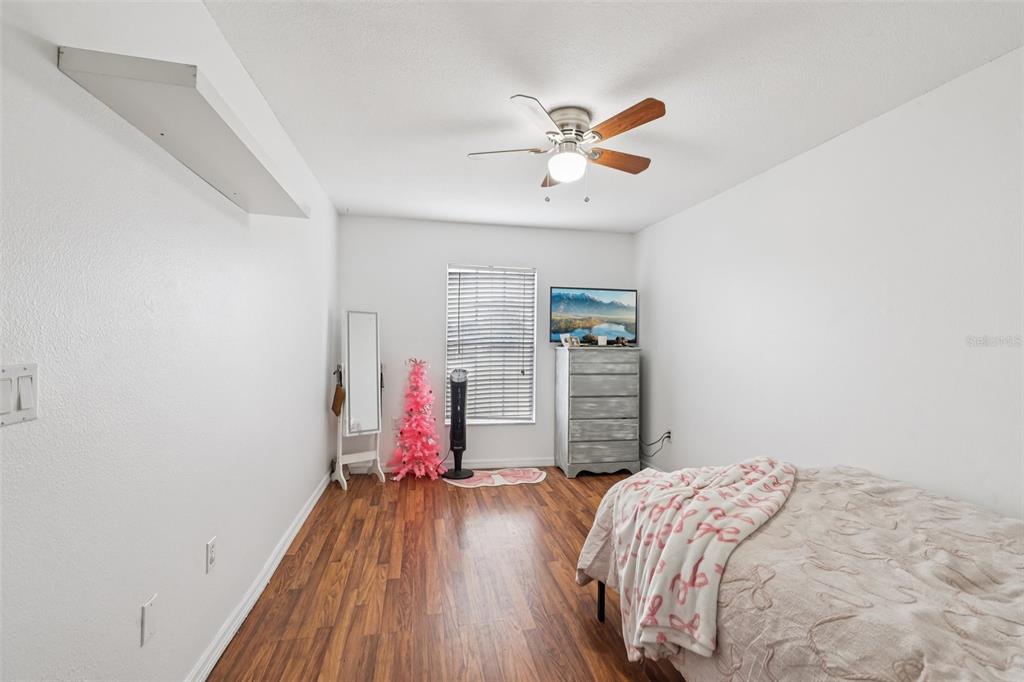 12315 Fort King Road Dade City, FL 33525 - Photo 32 of 77 a bedroom with a bed and a chandelier