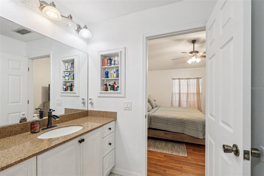 12315 Fort King Road Dade City, FL 33525 - Photo 41 of 77 a en suite bathroom with a double vanity sink and a mirror