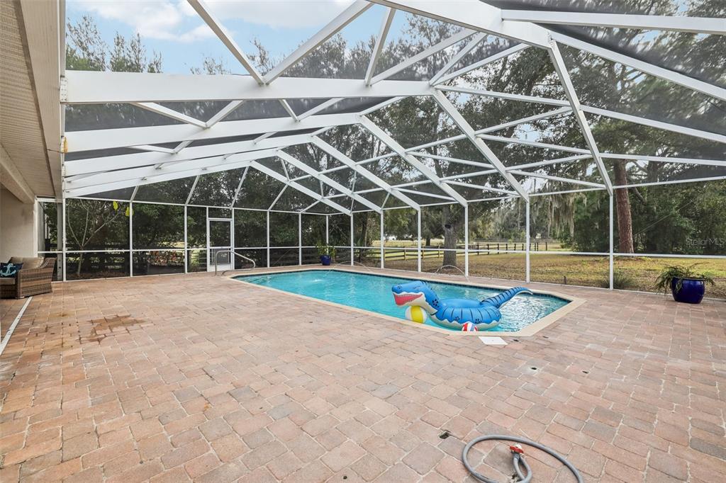 12315 Fort King Road Dade City, FL 33525 - Photo 52 of 77 a view of a swimming pool with a yard and potted plants