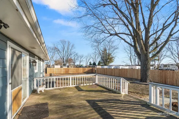 a view of a house with a large tree and wooden fence