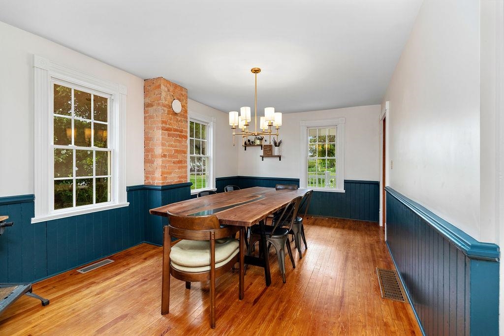 7549 Thomas Spring Road Bridgewater, VA 22812 - Photo 29 of 57 a dining room with wooden floor a chandelier a wooden table and chairs