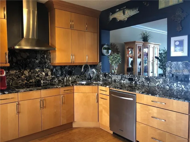 a kitchen with stainless steel appliances granite countertop a sink and cabinets