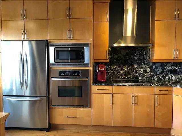 a kitchen with stainless steel appliances a stove a microwave and a refrigerator