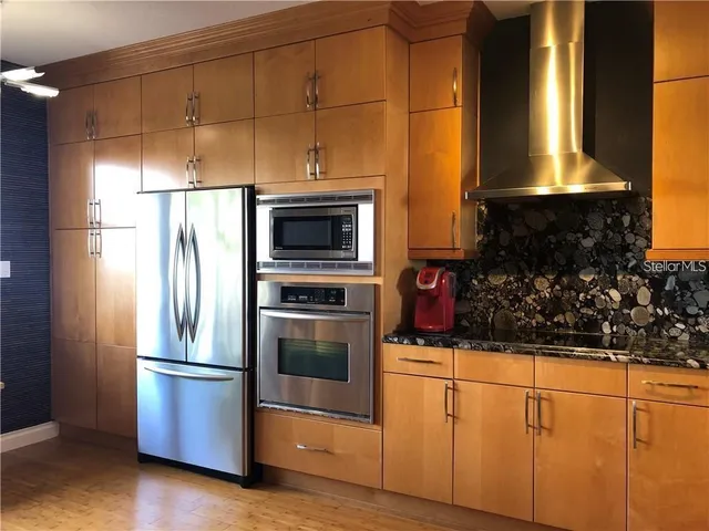 a kitchen with stainless steel appliances granite countertop a refrigerator and a stove