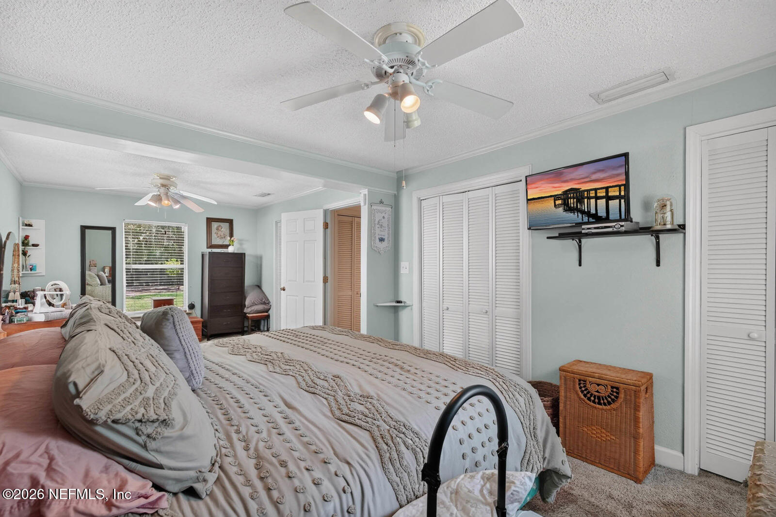 1950 Lightsey Road St. Augustine, FL 32084 - Photo 22 of 57 a bedroom with a large bed and a chandelier