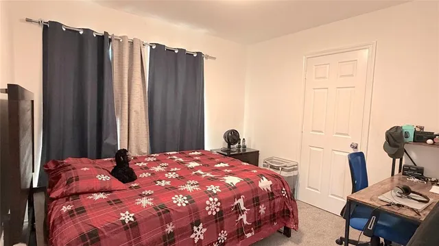 a bedroom with a bed and a flat tv screen