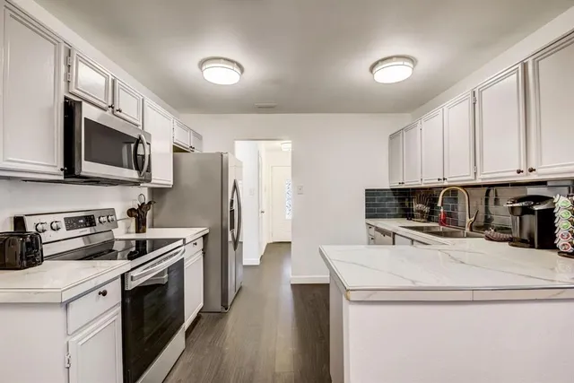 a kitchen with a sink a stove top oven and refrigerator