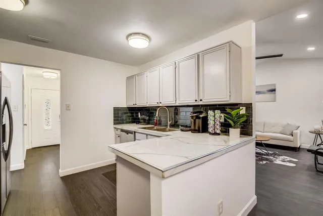 a kitchen with a refrigerator and a stove top oven