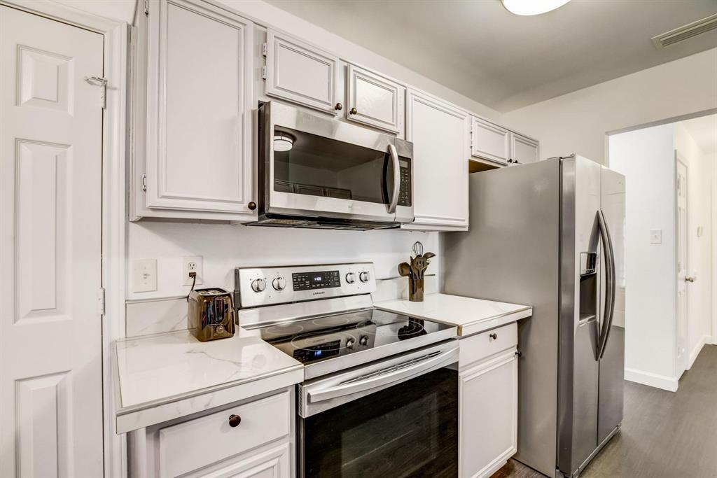 4233 Glen Ridge Drive Arlington, TX 76016 - Photo 15 of 34 a kitchen with stainless steel appliances white cabinets white stove a microwave and a refrigerator