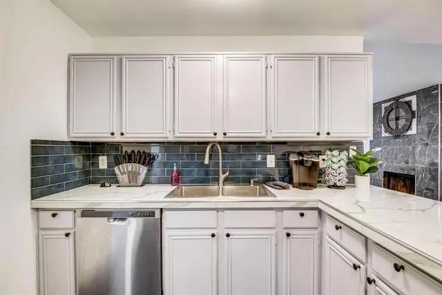 a kitchen with stainless steel appliances granite countertop a sink a stove and cabinets