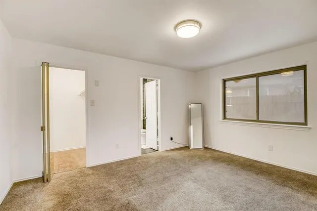 an empty room with a window and closet