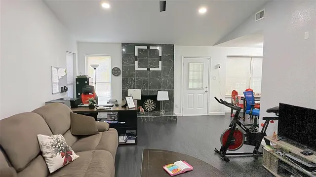 a living room with furniture a flat screen tv and a window