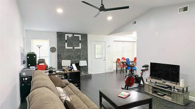 a living room with furniture a flat screen tv and a window