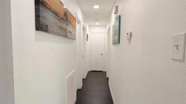 a view of a hallway with wooden floor