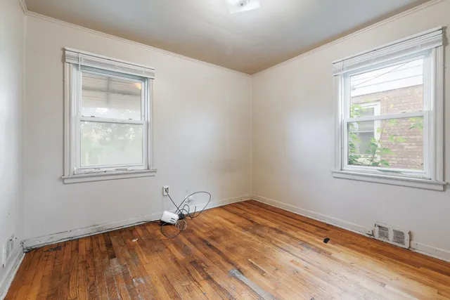 a view of a room with wooden floor and windows
