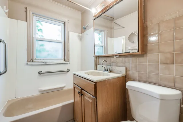 a bathroom with a sink toilet vanity and bathtub