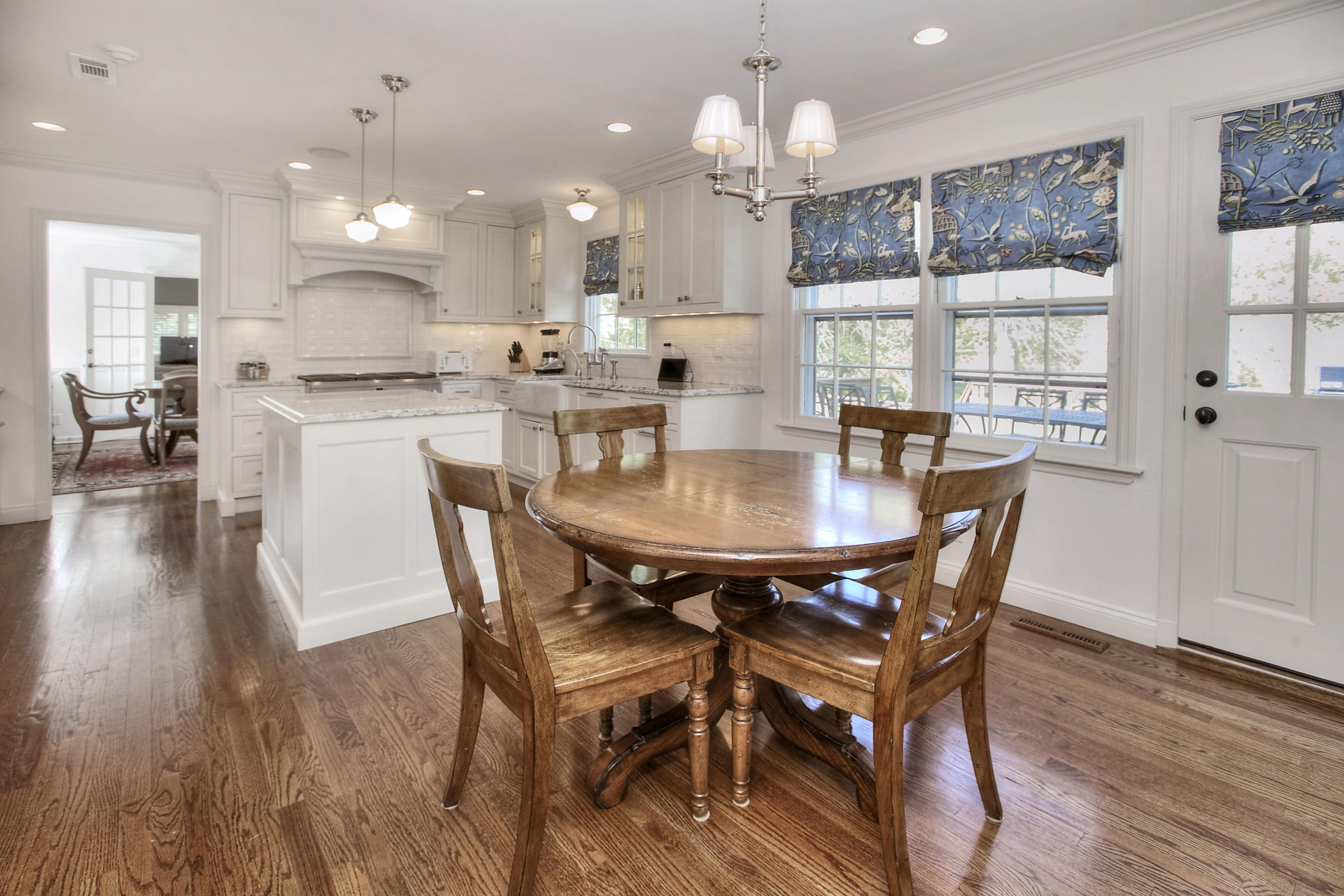 195 Ponus Ridge Road New Canaan, CT 06840 - Photo 6 of 28 a dining room with wooden floor a chandelier a wooden table and chairs