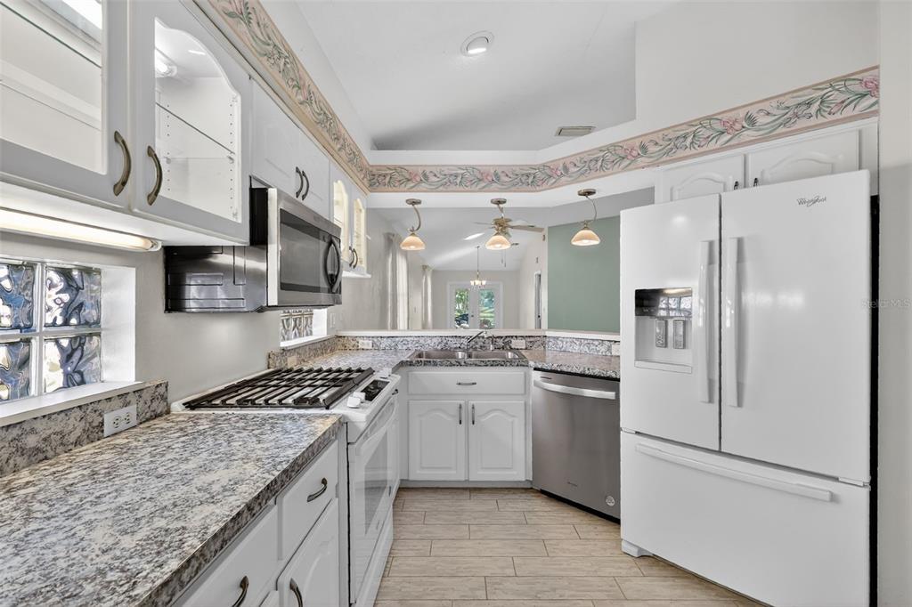 5500 Laver Street Leesburg, FL 34748 - Photo 11 of 35 a kitchen with stainless steel appliances granite countertop a sink stove and refrigerator