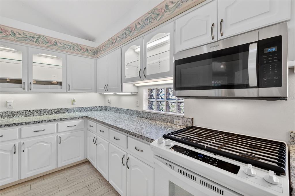 5500 Laver Street Leesburg, FL 34748 - Photo 13 of 35 a kitchen with stainless steel appliances white cabinets and a stove top oven