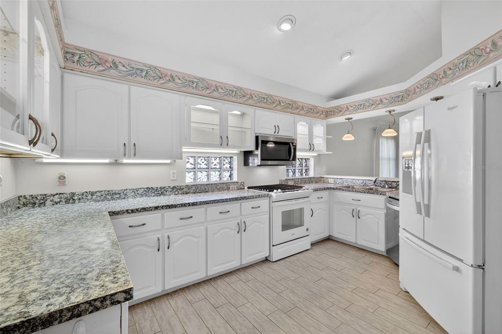 5500 Laver Street Leesburg, FL 34748 - Photo 10 of 35 a large kitchen with granite countertop cabinets stainless steel appliances a sink and a island