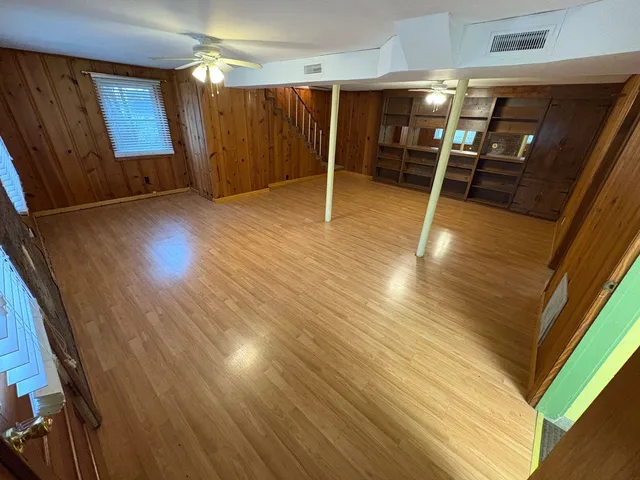 a view of empty room with wooden floor