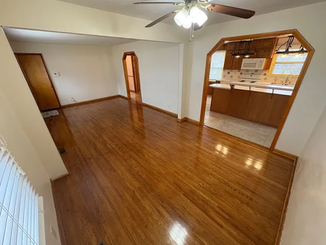a view of a livingroom with wooden floor and a ceiling fan