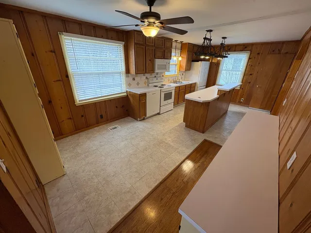 a living room with chairs and a refrigerator