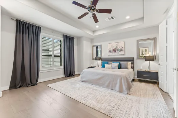 a spacious bedroom with a large bed and a chandelier