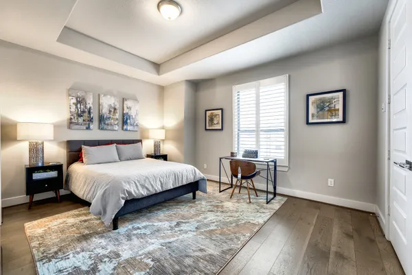 a spacious bedroom with a bed a table and chair