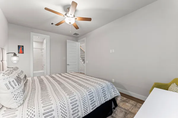 a bedroom with a bed and a ceiling fan