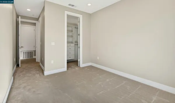 an empty room with closet and a bathroom