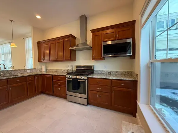 a kitchen with stainless steel appliances granite countertop a stove a sink and a microwave