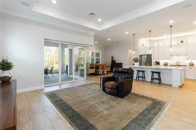 a kitchen with stainless steel appliances kitchen island granite countertop a table chairs sink and cabinets