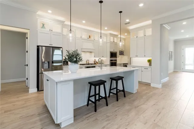 a kitchen with stainless steel appliances granite countertop a stove and a white cabinets